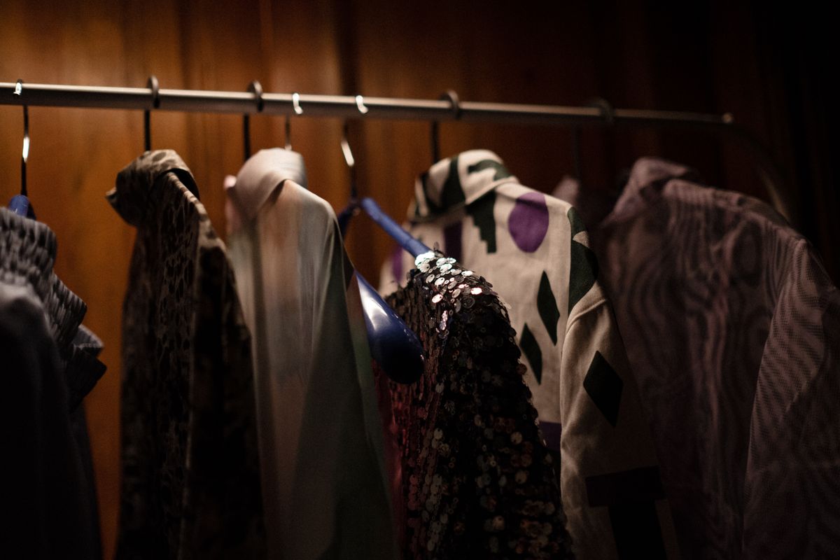 Camisas no cabide contra o painel de carvalho da nervura